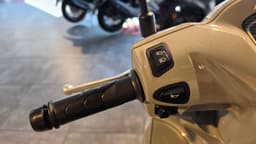 Detalle del manillar de una moto Honda Vision 110 color beige