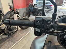 Detalle del manillar de una motocicleta con varios botones de control y puño.