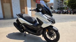 Scooter Honda Forza 125 blanco aparcado en la calle