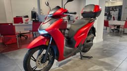 Scooter Honda SH 125 rojo con baúl en exposición de concesionario