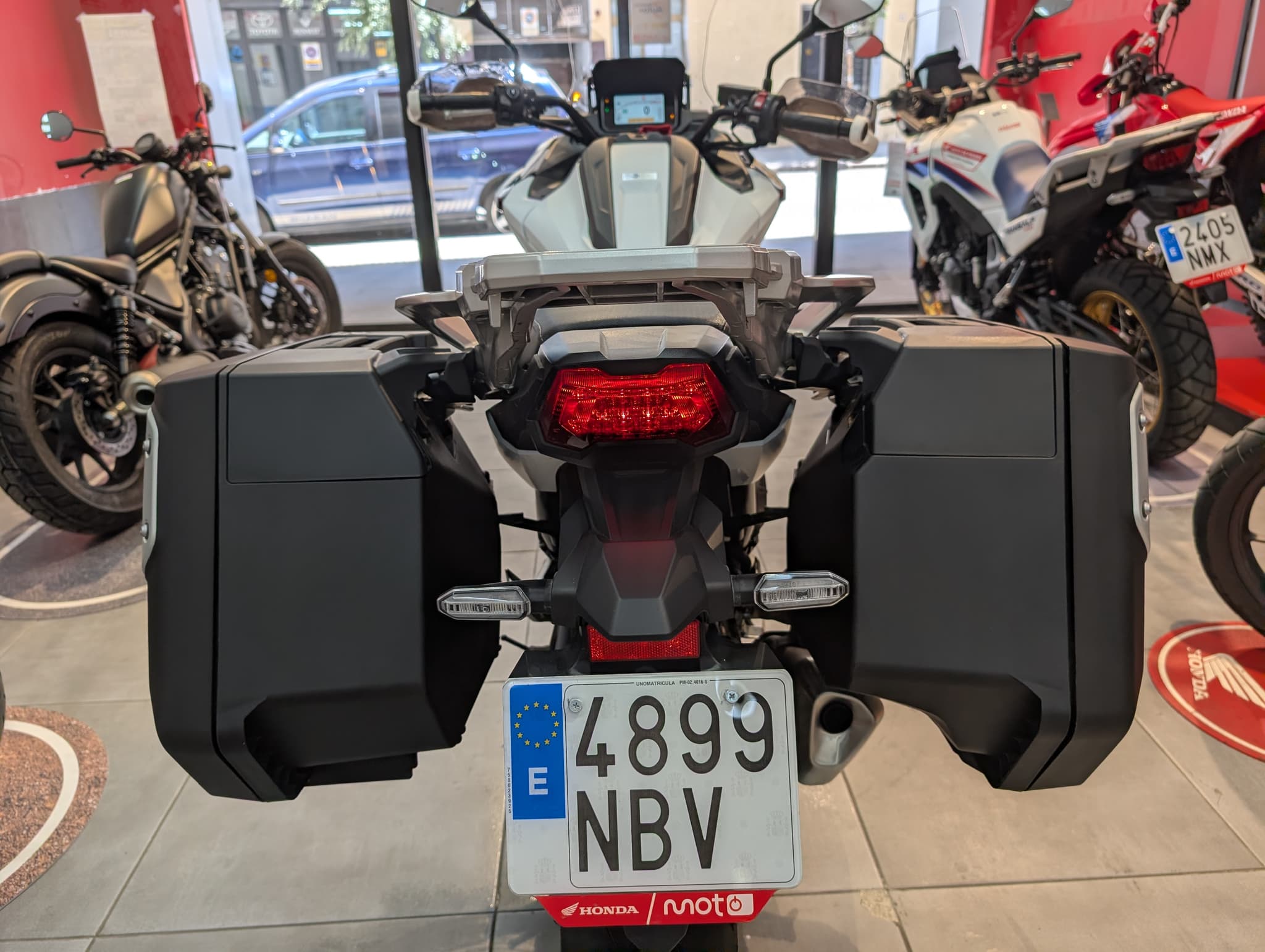 Vista trasera de una Honda Honda NC750X blanca con maletas laterales negras.