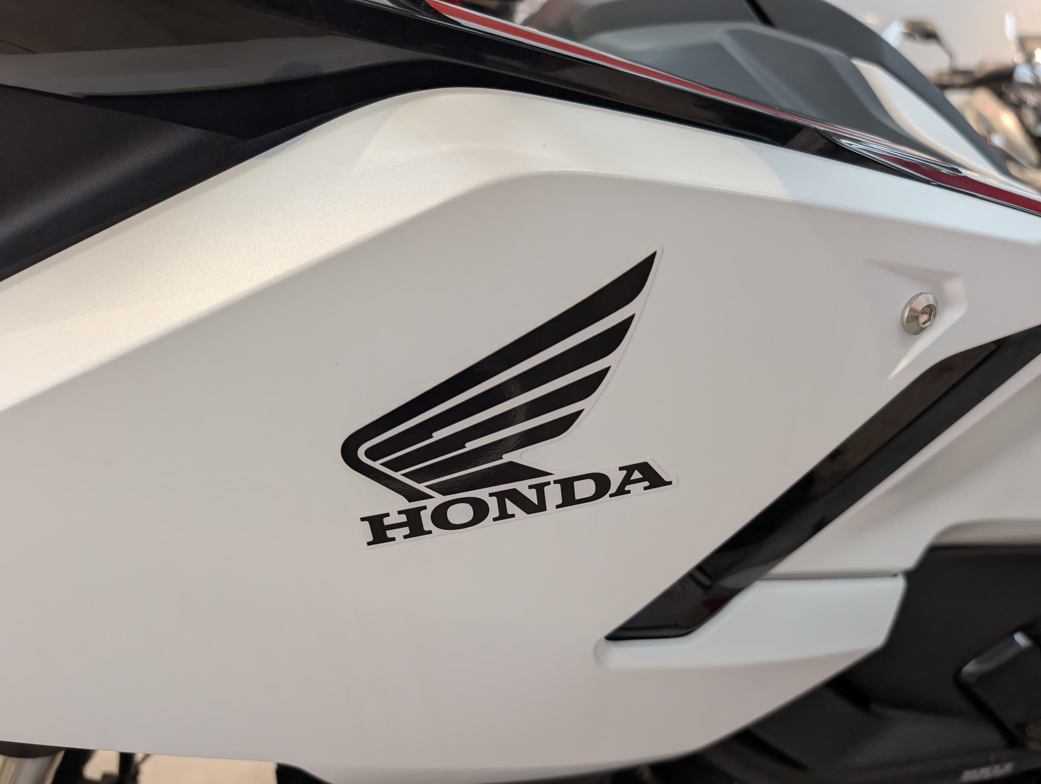 Logo de Honda en el carenado blanco de una motocicleta.