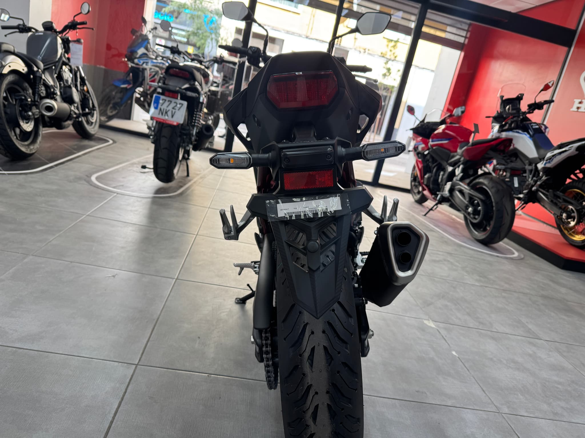 Vista trasera de una moto Honda CB750 Hornet negra en un concesionario