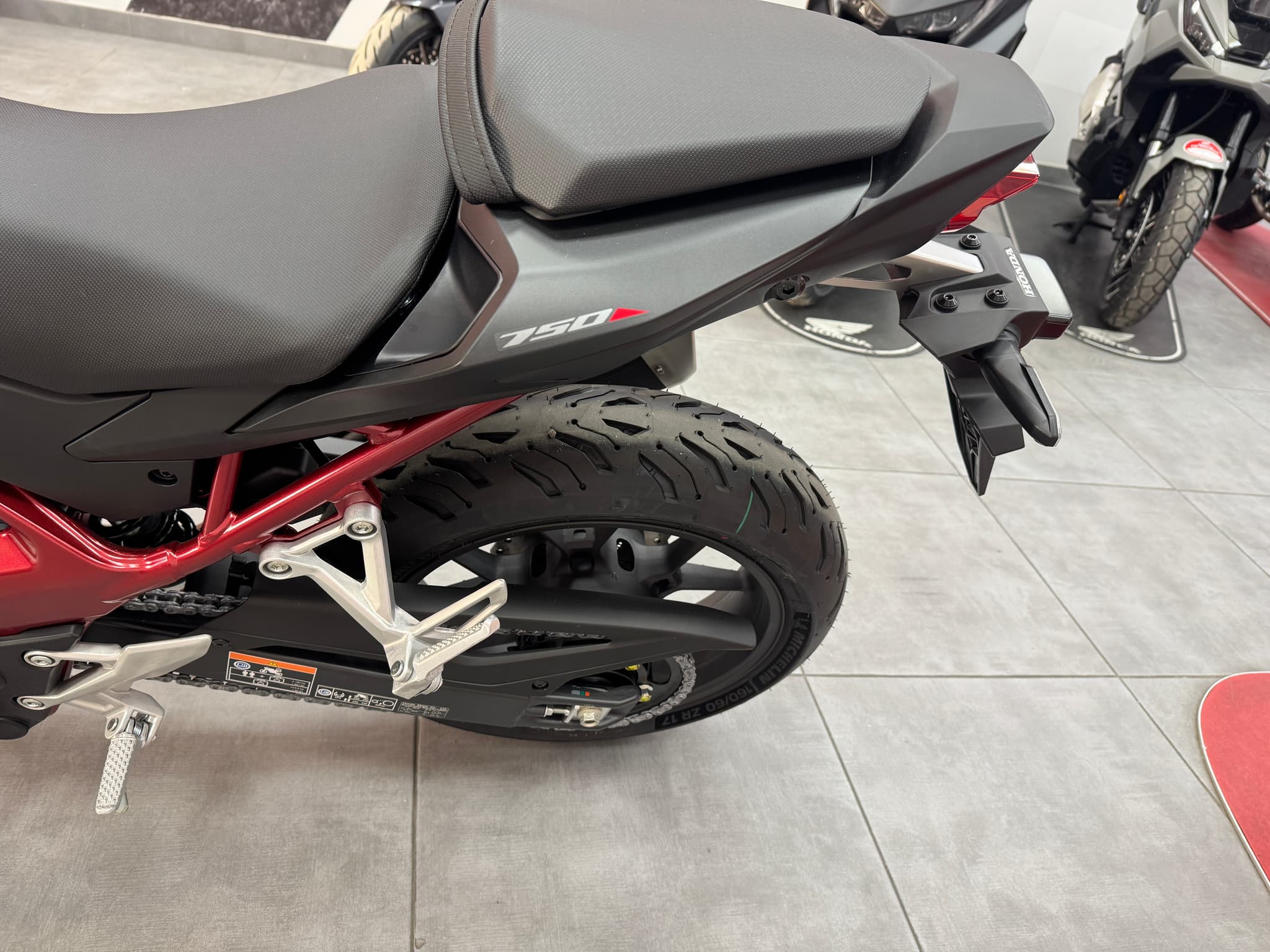 Parte trasera de la Honda CB750 Hornet con chasis rojo y asiento negro.