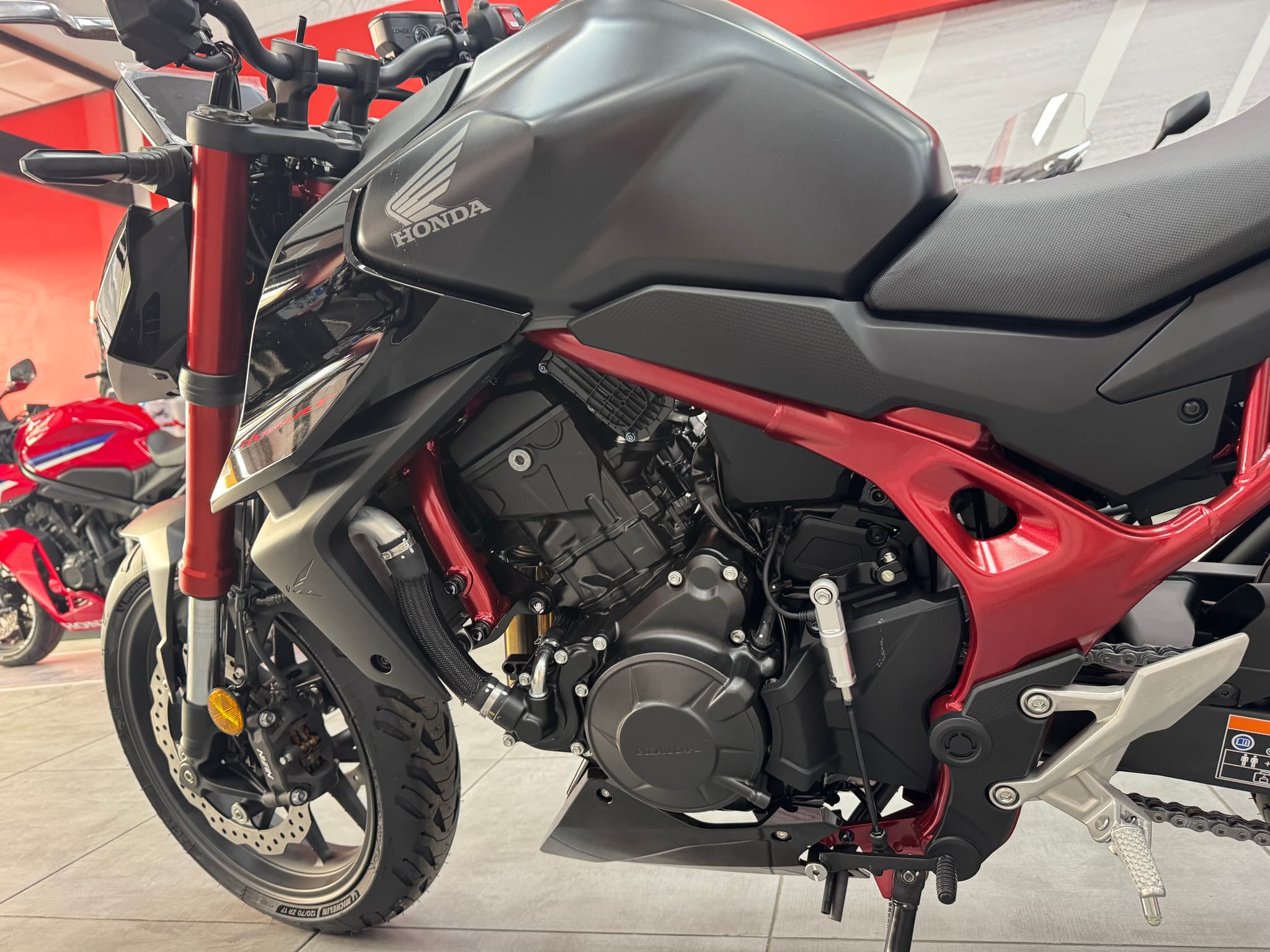 Honda CB750 Hornet negra con chasis rojo en exposición