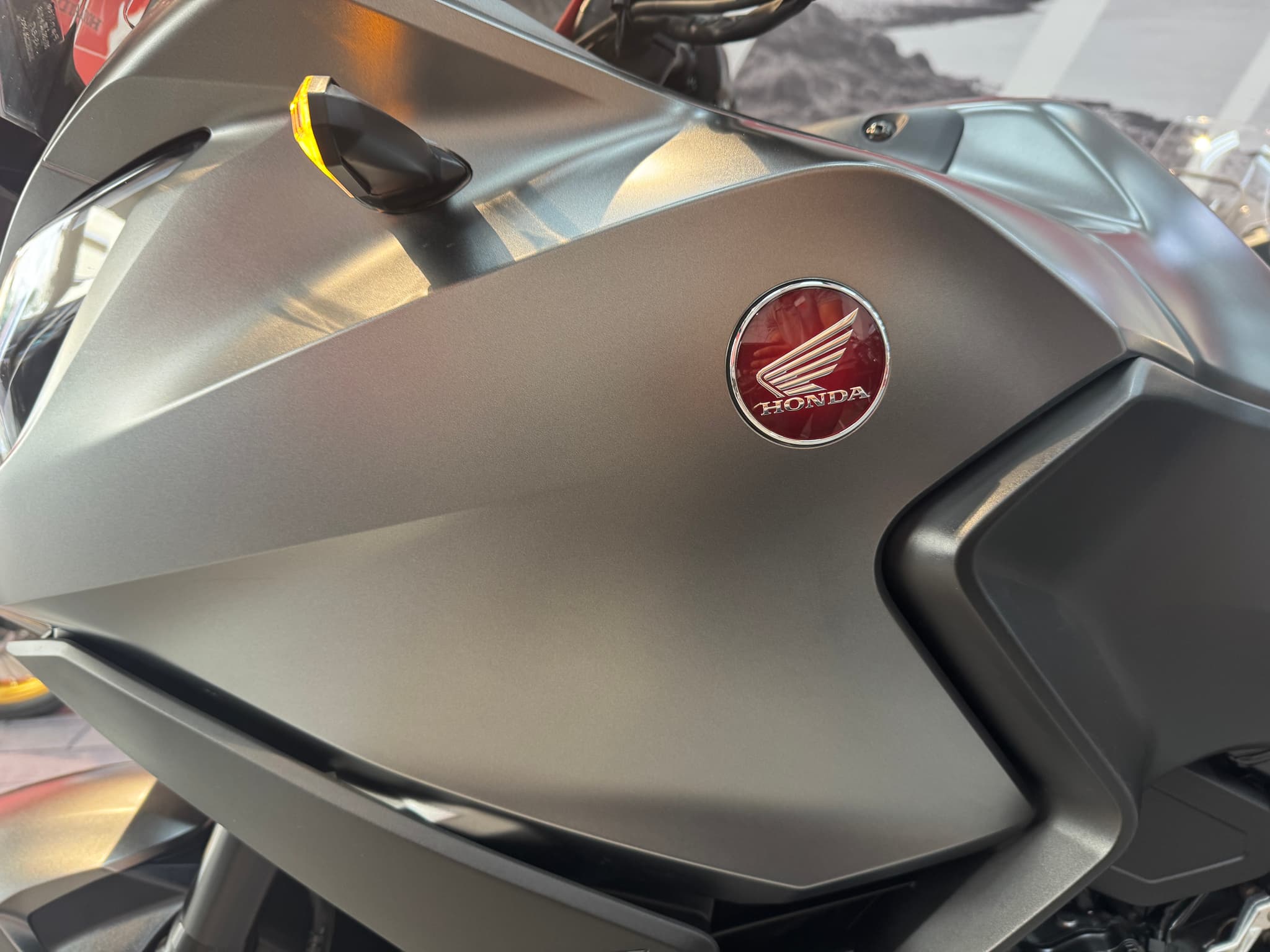 Logo de Honda en el carenado de una motocicleta de color gris mate.