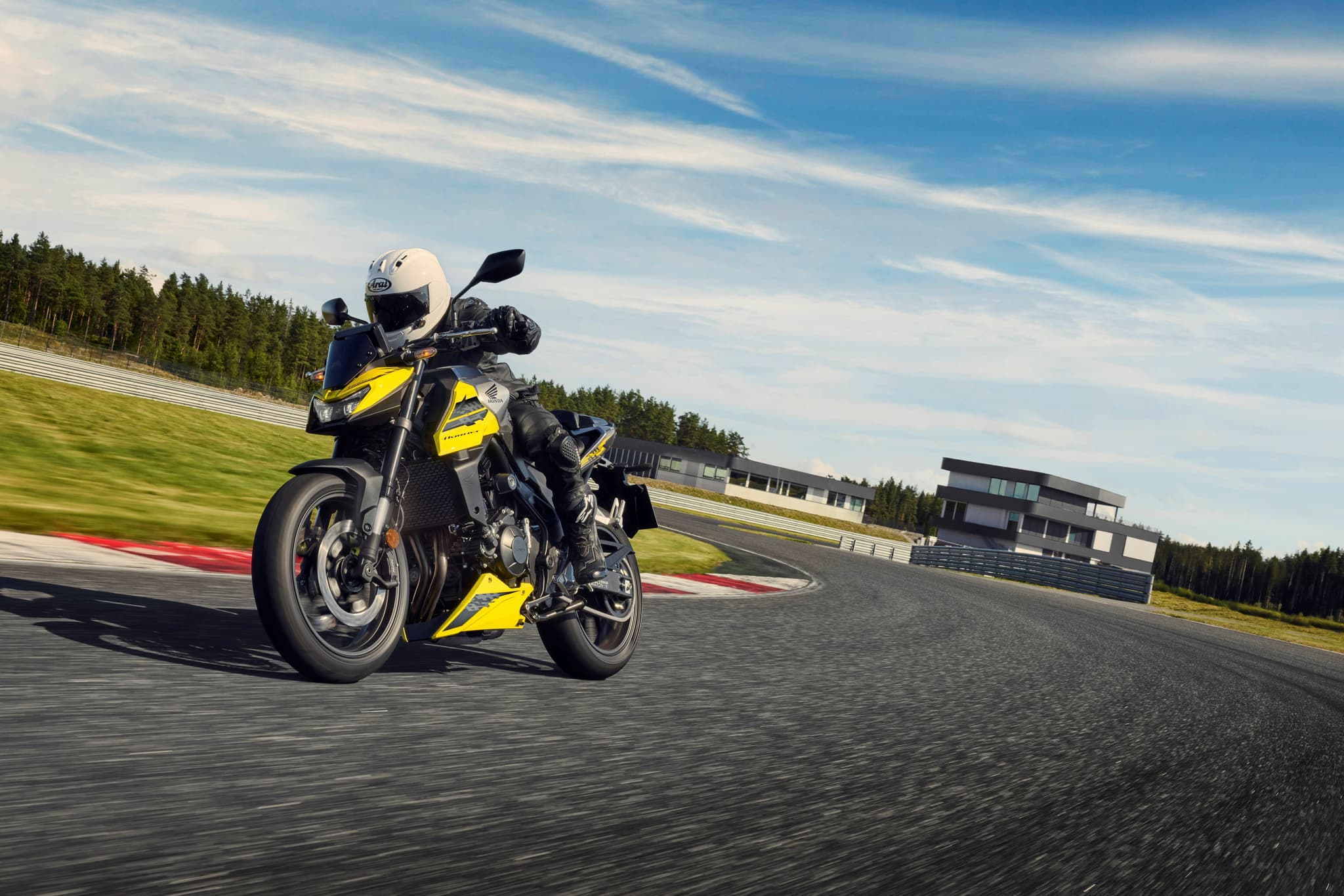 Honda CB750 Hornet amarilla y negra con piloto en pista de carreras
