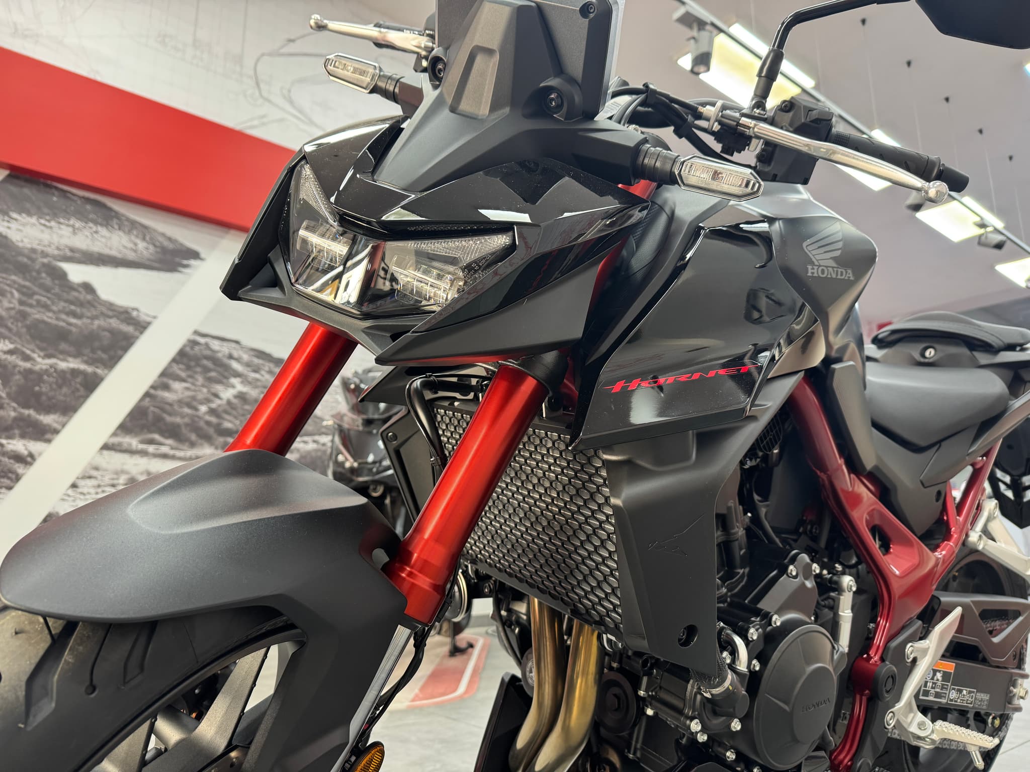 Honda CB750 Hornet negra con horquilla y chasis rojos en exposición