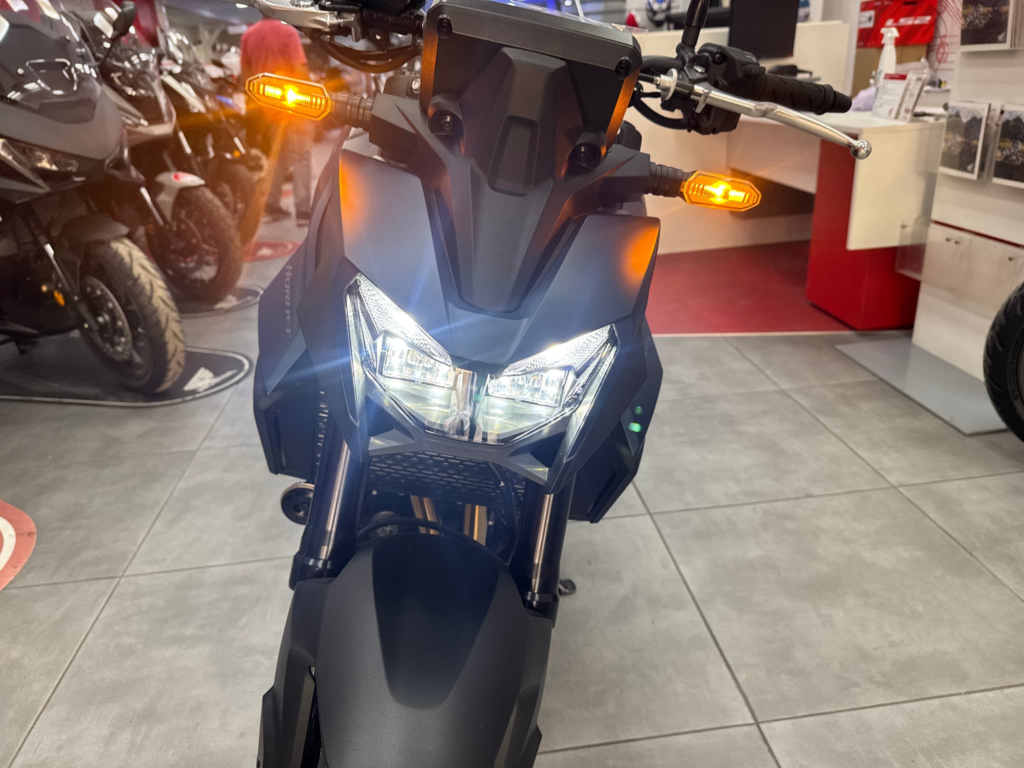 Vista frontal de una Honda CB750 Hornet negra con luces encendidas