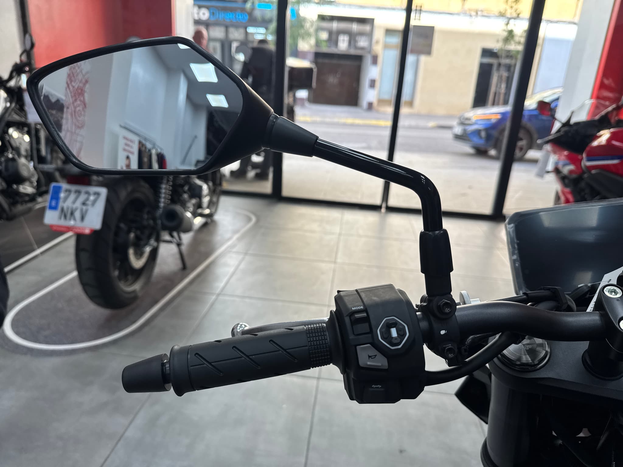 Manillar izquierdo y espejo retrovisor de una Honda CB750 Hornet negra en un concesionario