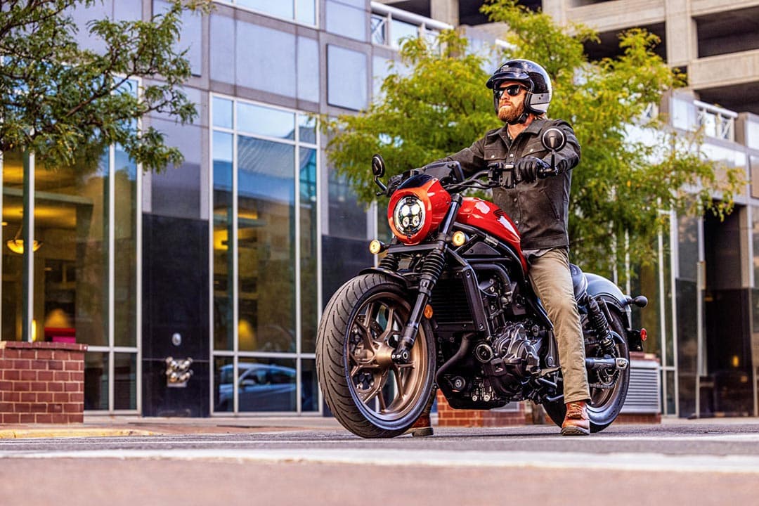 La cmx1100 SE 2025 en color YR-368 es conducida por un motociclista por la calle de una ciudad