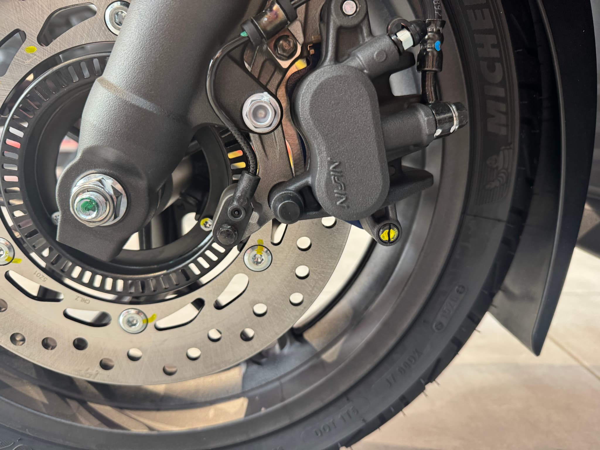 Freno de disco delantero de la Honda Forza 125 con pinza Nissin y neumático Michelin.
