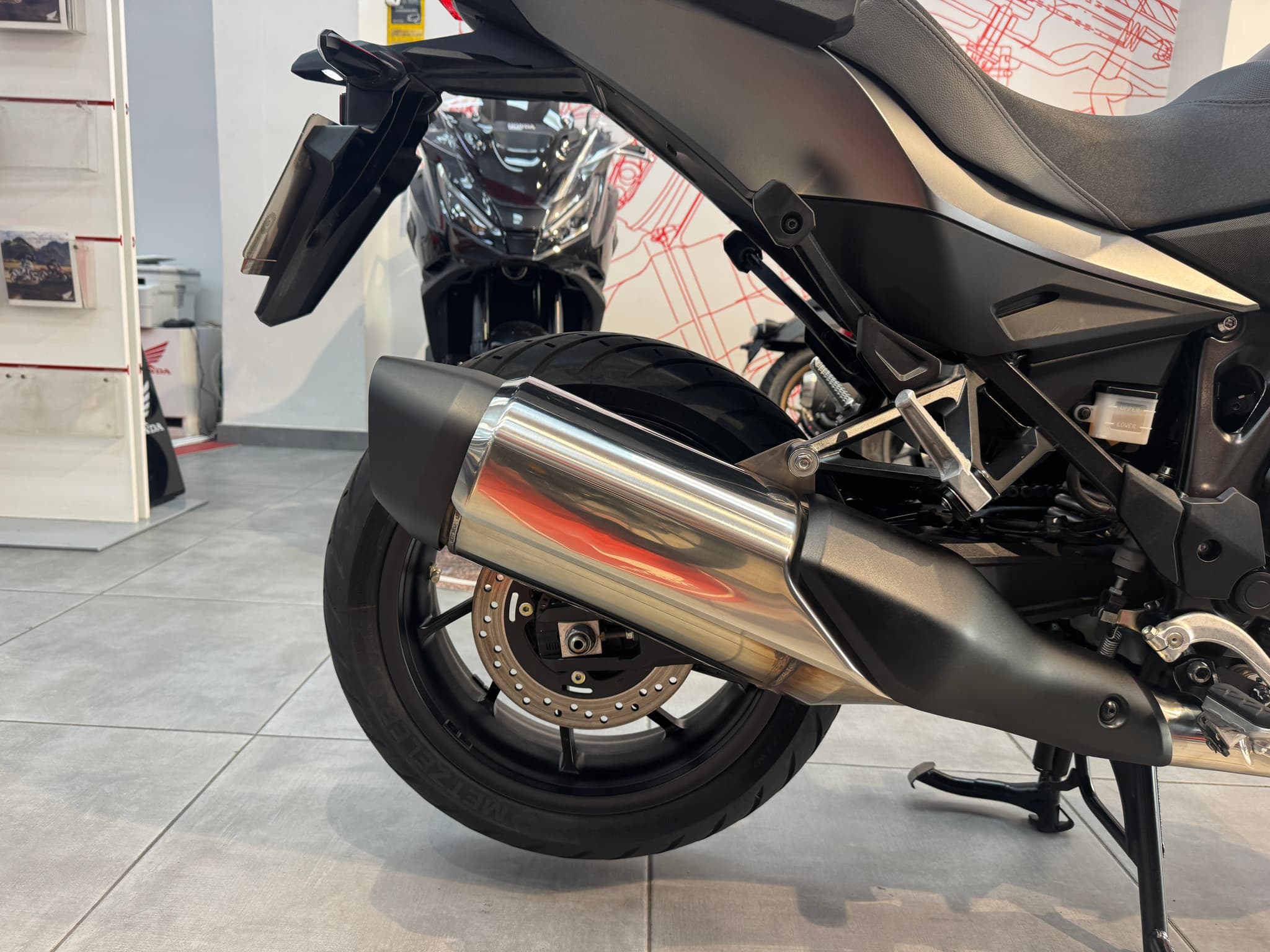 Vista detallada del escape cromado y la rueda trasera de una motocicleta negra