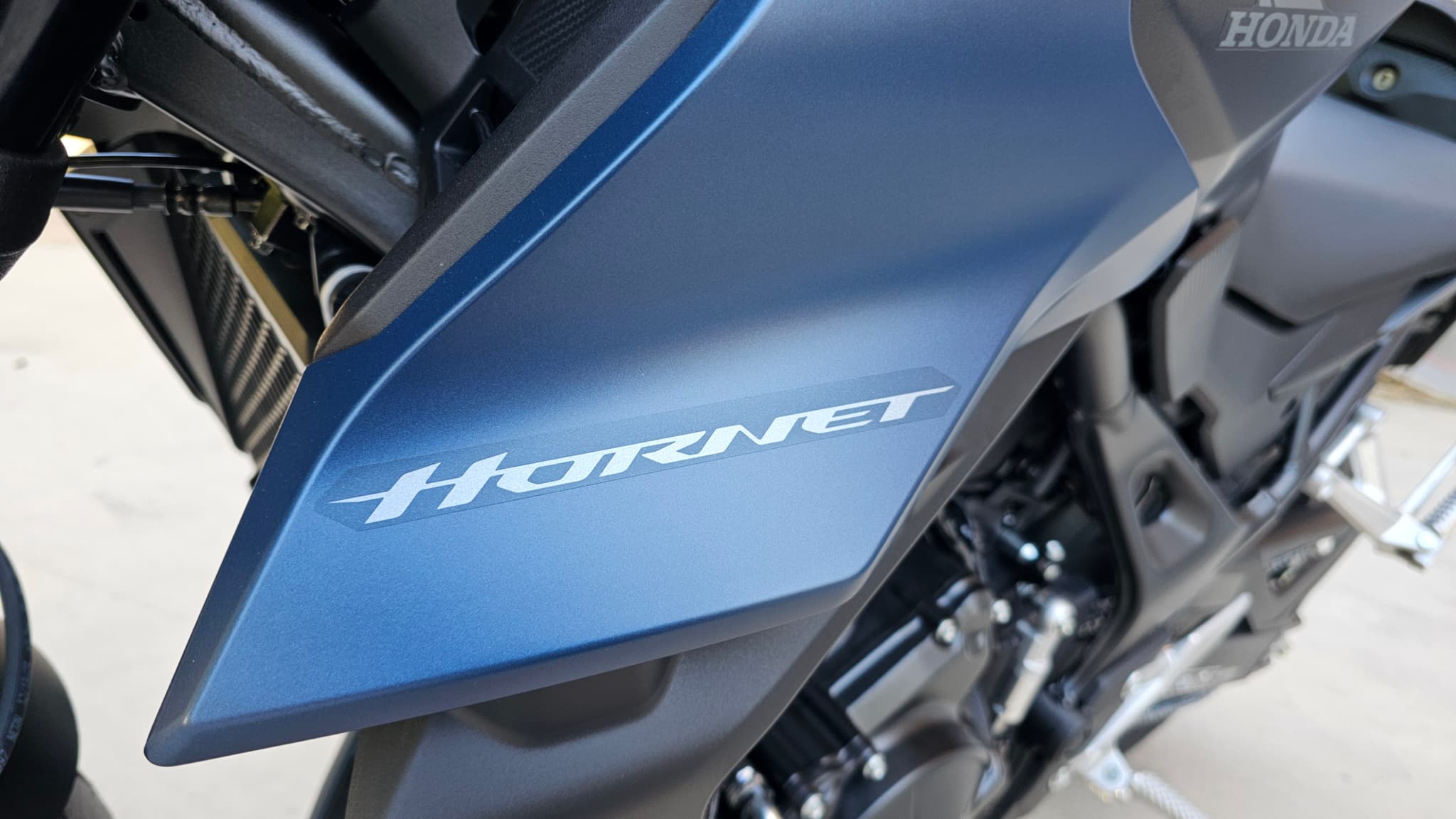 Lateral de la Honda CB750 Hornet en color azul mate con el logo Hornet