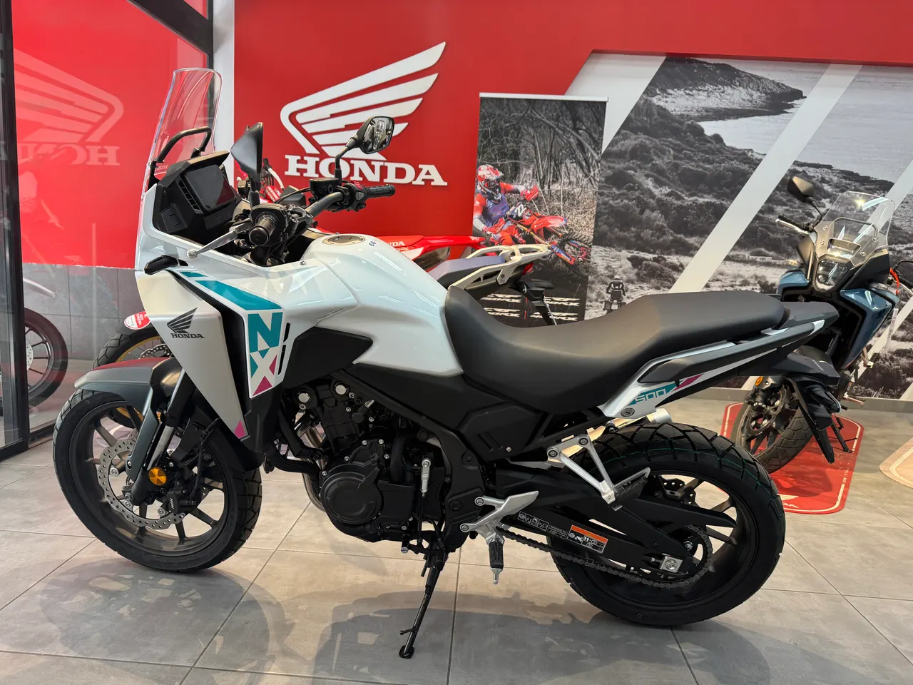 Honda NX500 E-Clutch blanca con gráficos turquesa y rosa