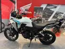Honda NX500 E-Clutch blanca con gráficos turquesa y rosa