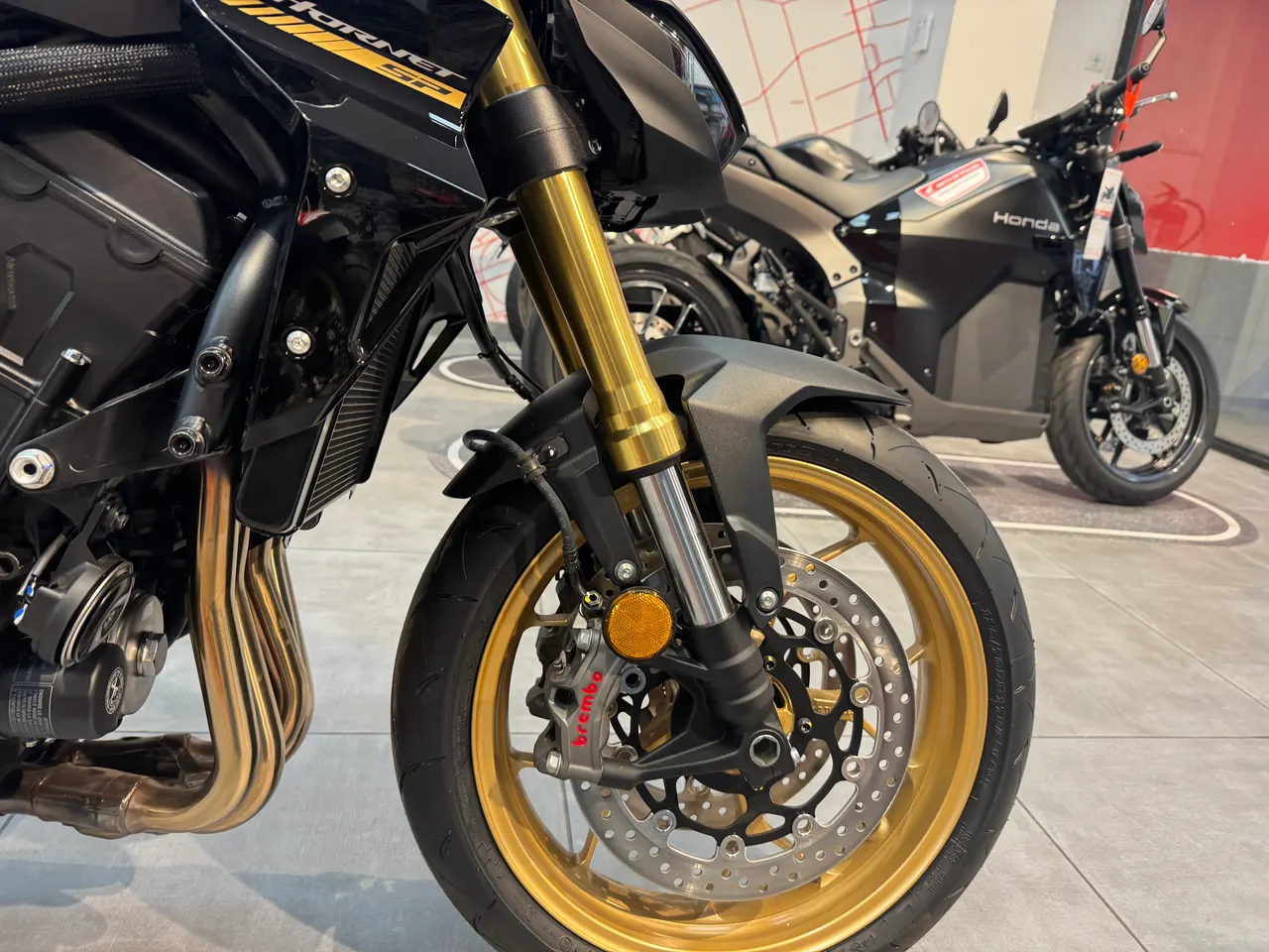 Detalle frontal de una moto Honda Hornet 1000 SP negra con detalles dorados