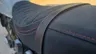 Detalle del asiento de una moto Honda GB350S azul con costuras rojas