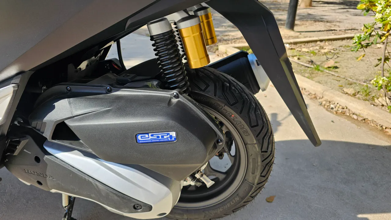 Detalle de la rueda trasera, amortiguador y motor de una Honda PCX 125 negra