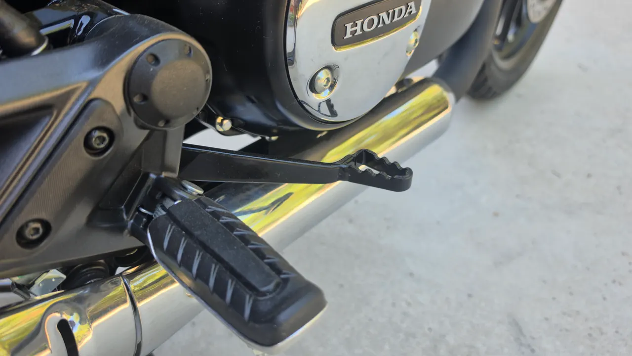Detalle de la estribera y escape de una Honda GB350S azul
