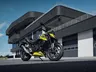 Honda CB750 Hornet gris y amarilla aparcada frente a un edificio moderno