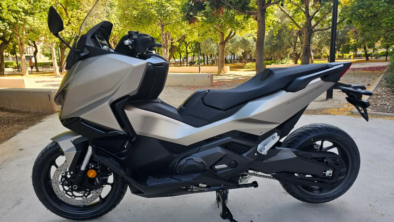 Honda Forza 750 gris warm mate metalizado aparcada en un parque