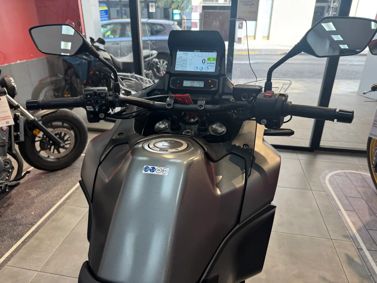 Manillar y panel de control de una moto gris