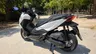 Honda Forza 125 blanca estacionada en un parque