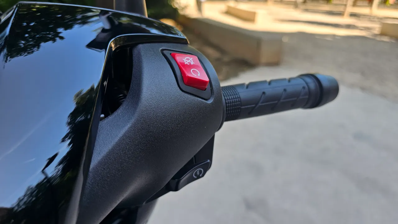 Detalle del manillar de una moto Honda SH350i, mostrando el puño y el botón de encendido/apagado.