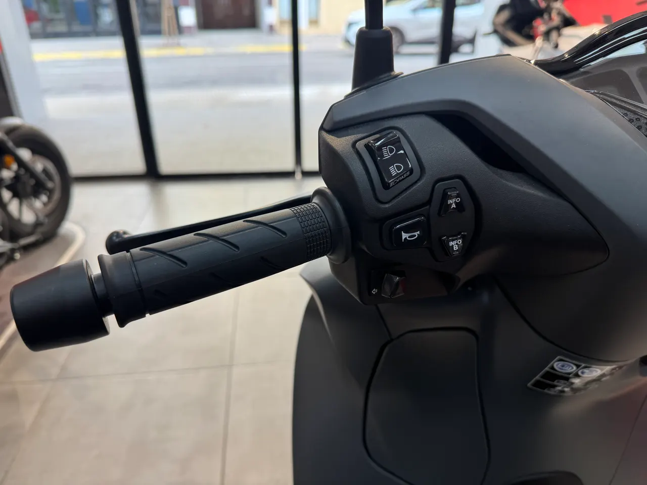 Detalle del manillar y controles de una moto Honda SH 350 i gris rock mate