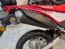 Parte trasera de la Honda CRF300L roja y blanca con escape y rueda