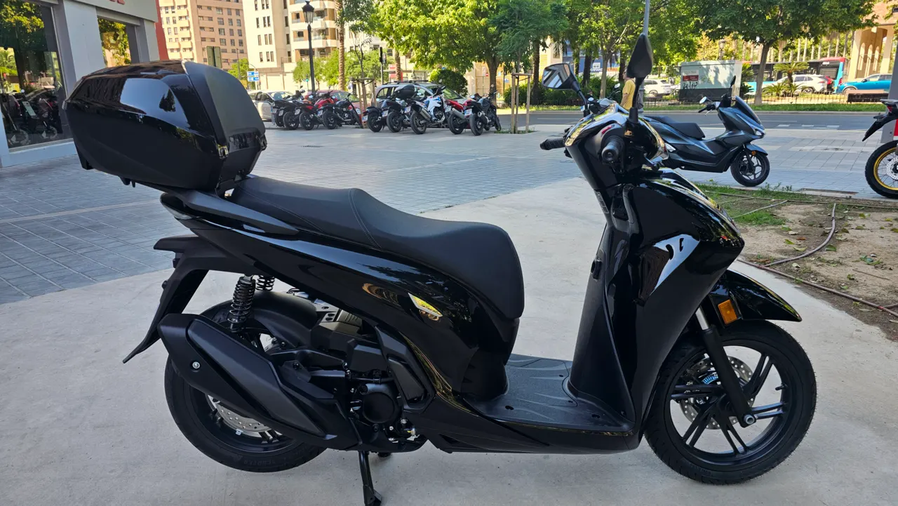 Honda SH350i negra con baúl trasero aparcada en ciudad