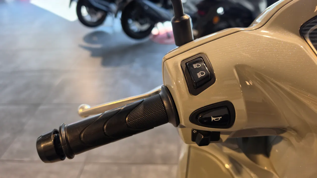 Detalle del manillar de una moto Honda Vision 110 color beige