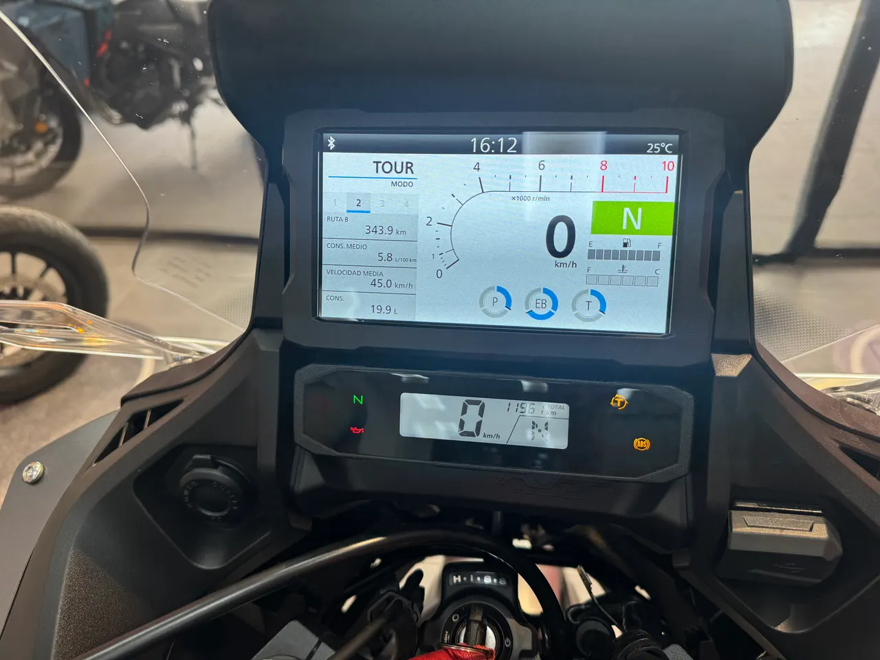 Pantalla digital de moto mostrando información en modo Tour, velocímetro, odómetro y temperatura.