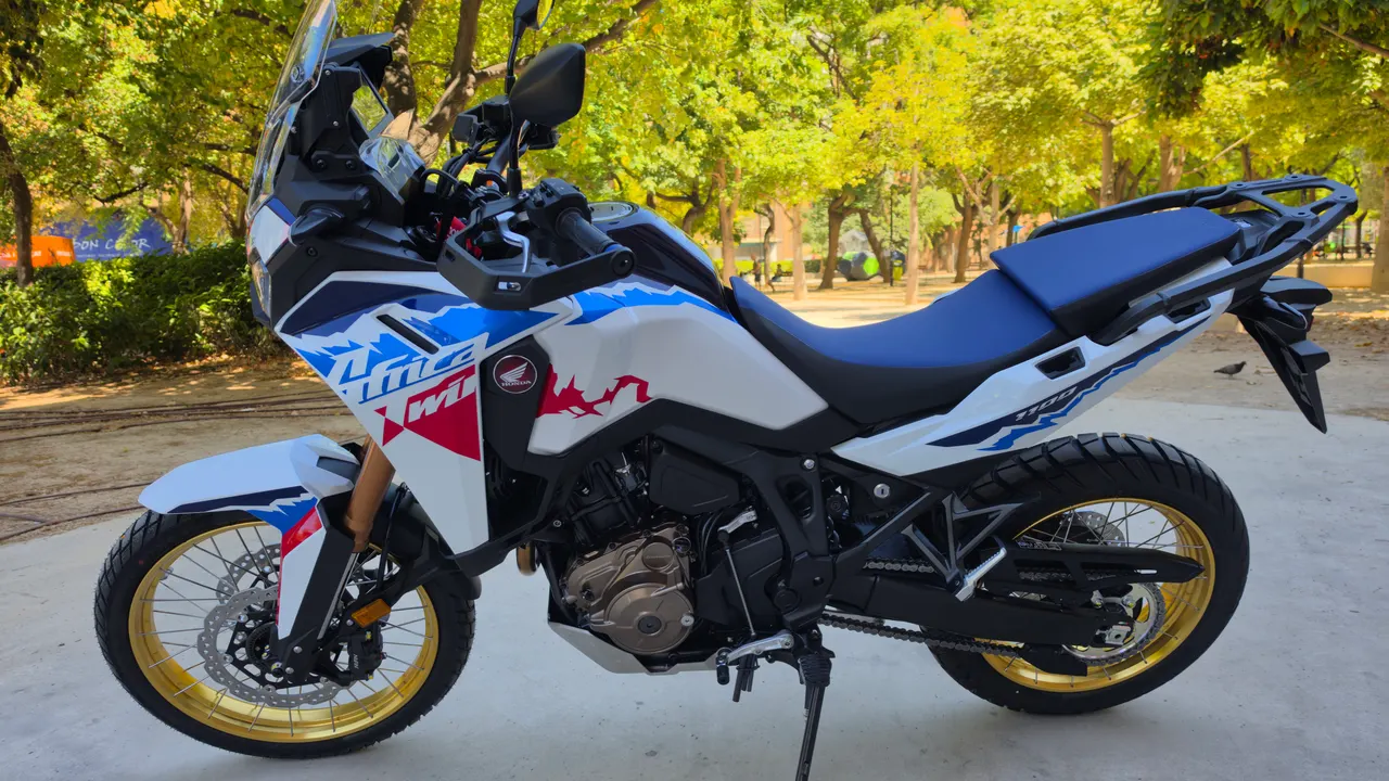 Moto Honda Africa Twin blanca, azul y roja con llantas doradas