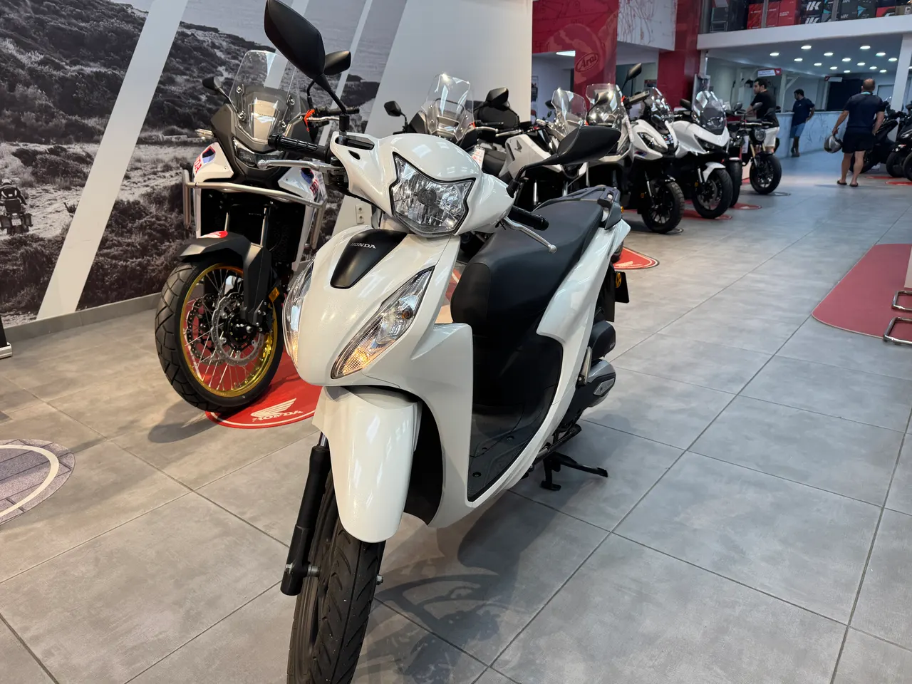 Scooter Honda Vision blanca en un concesionario de motos