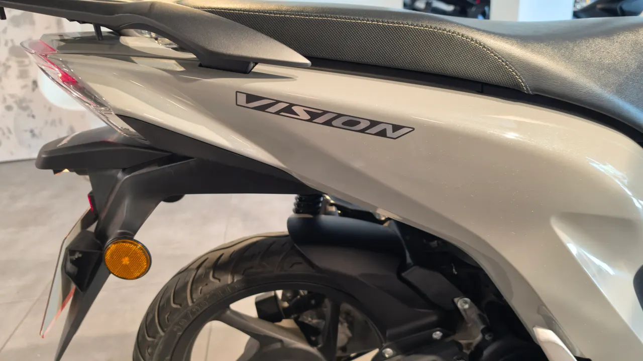 Detalle lateral de una moto Honda Vision 110 de color blanco