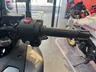 Detalle del manillar de una motocicleta con el puño de acelerador, botones de control y maneta de freno.