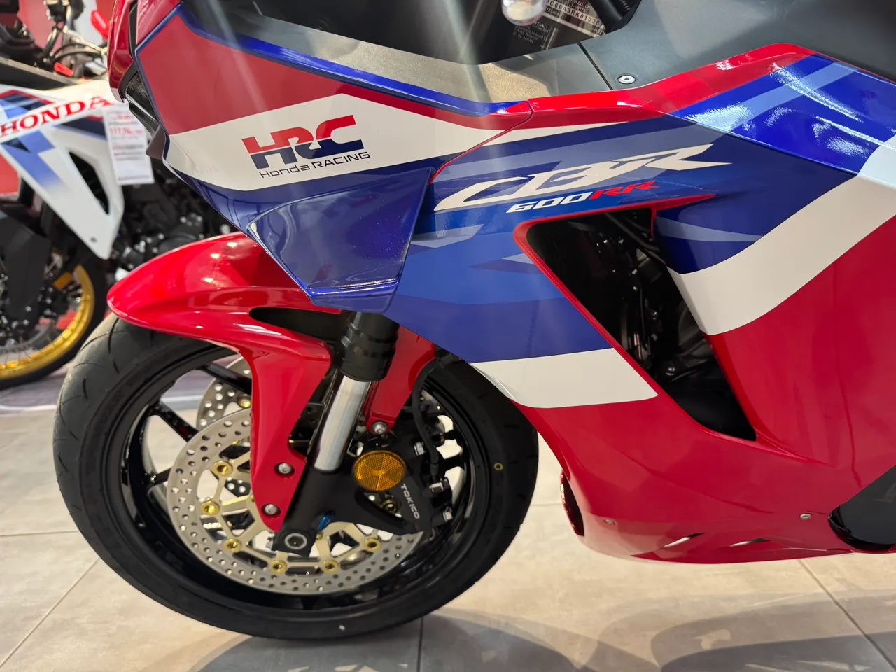 Detalle frontal de una moto Honda CBR 600RR en color rojo, blanco y azul.