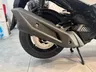 Escape, rueda trasera y freno de disco de una Honda Forza 125