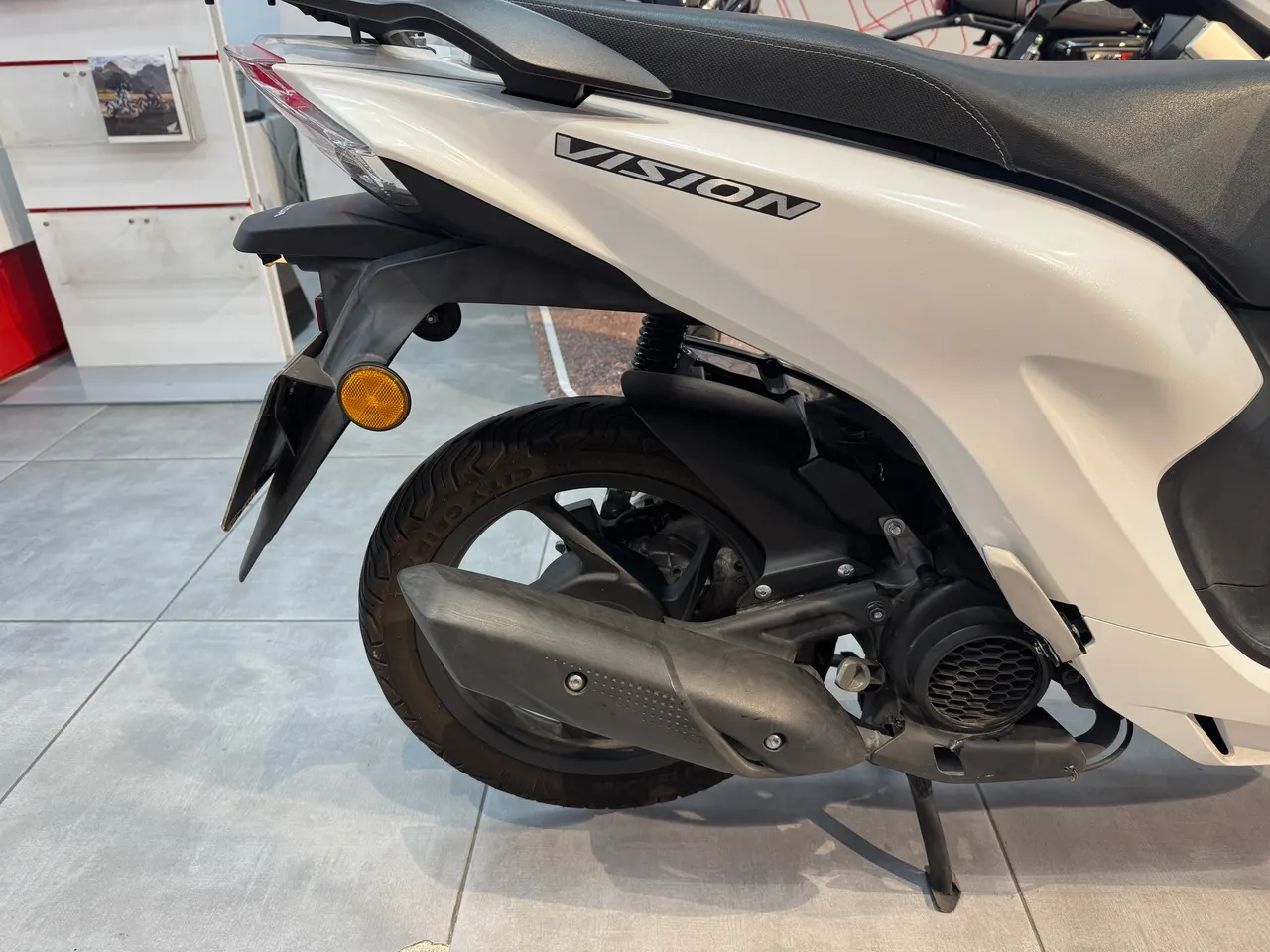 Vista lateral de una moto Honda Vision blanca