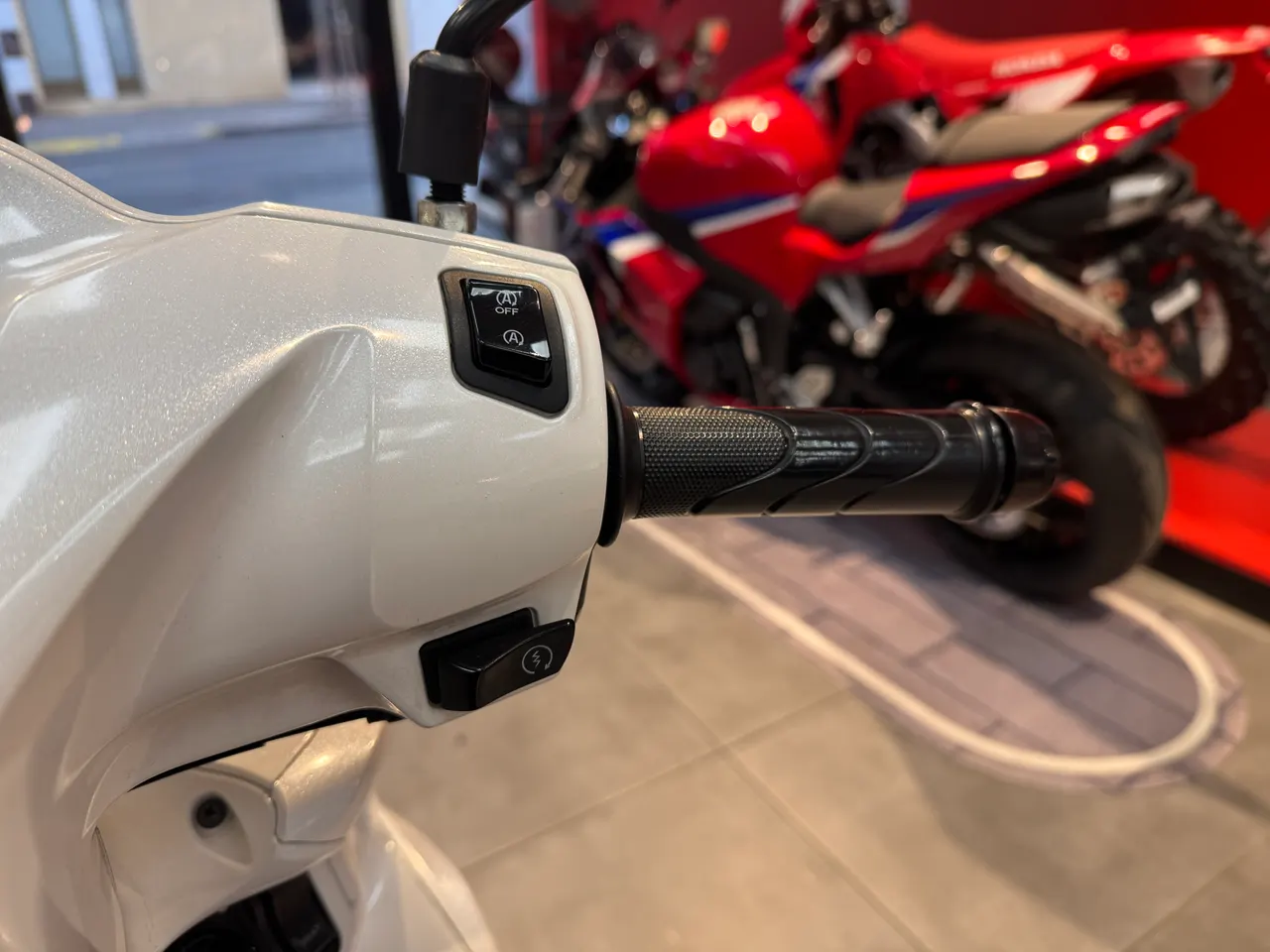 Detalle del manillar de una moto Honda Vision de color blanco