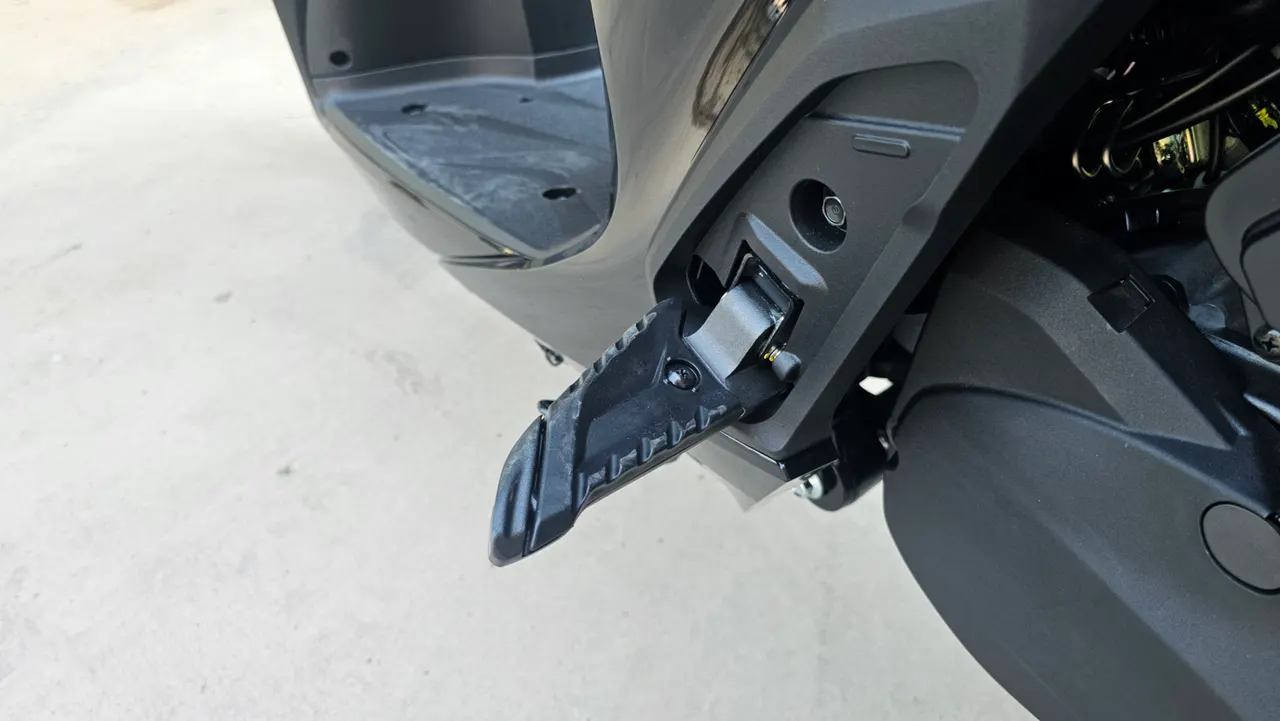 Detalle de la estribera desplegada de una moto Honda SH350i