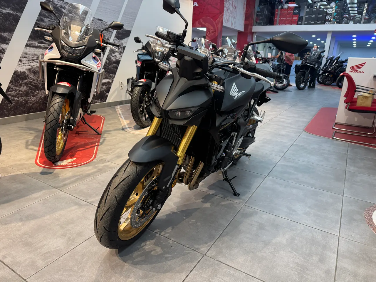 Honda Hornet 1000 SP negra con detalles dorados en un concesionario