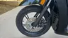 Detalle de la rueda delantera de una moto Honda SH350i negra