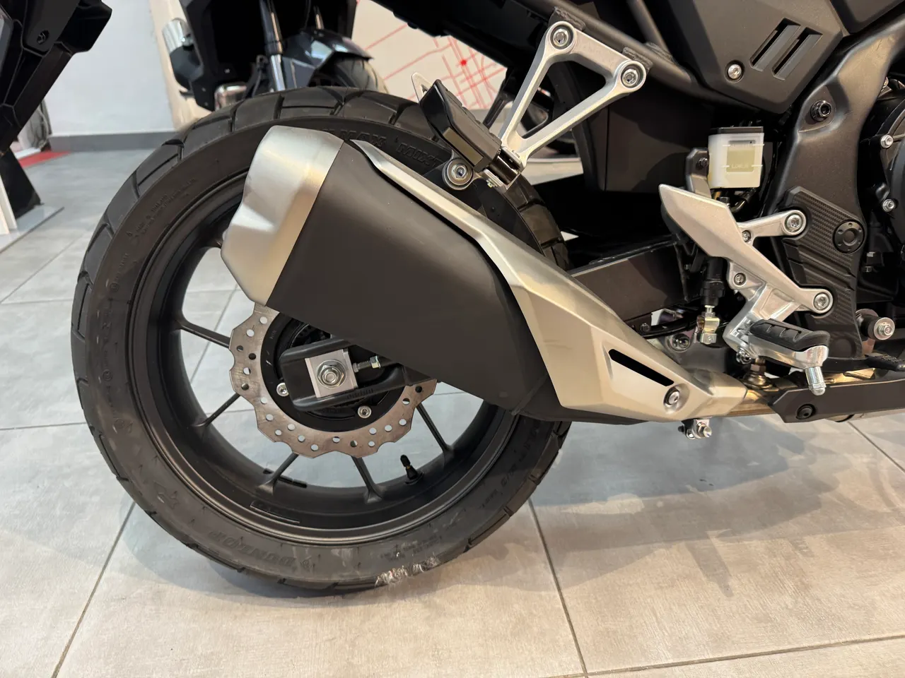 Vista trasera del escape y la rueda de una Honda NX500 E-Clutch