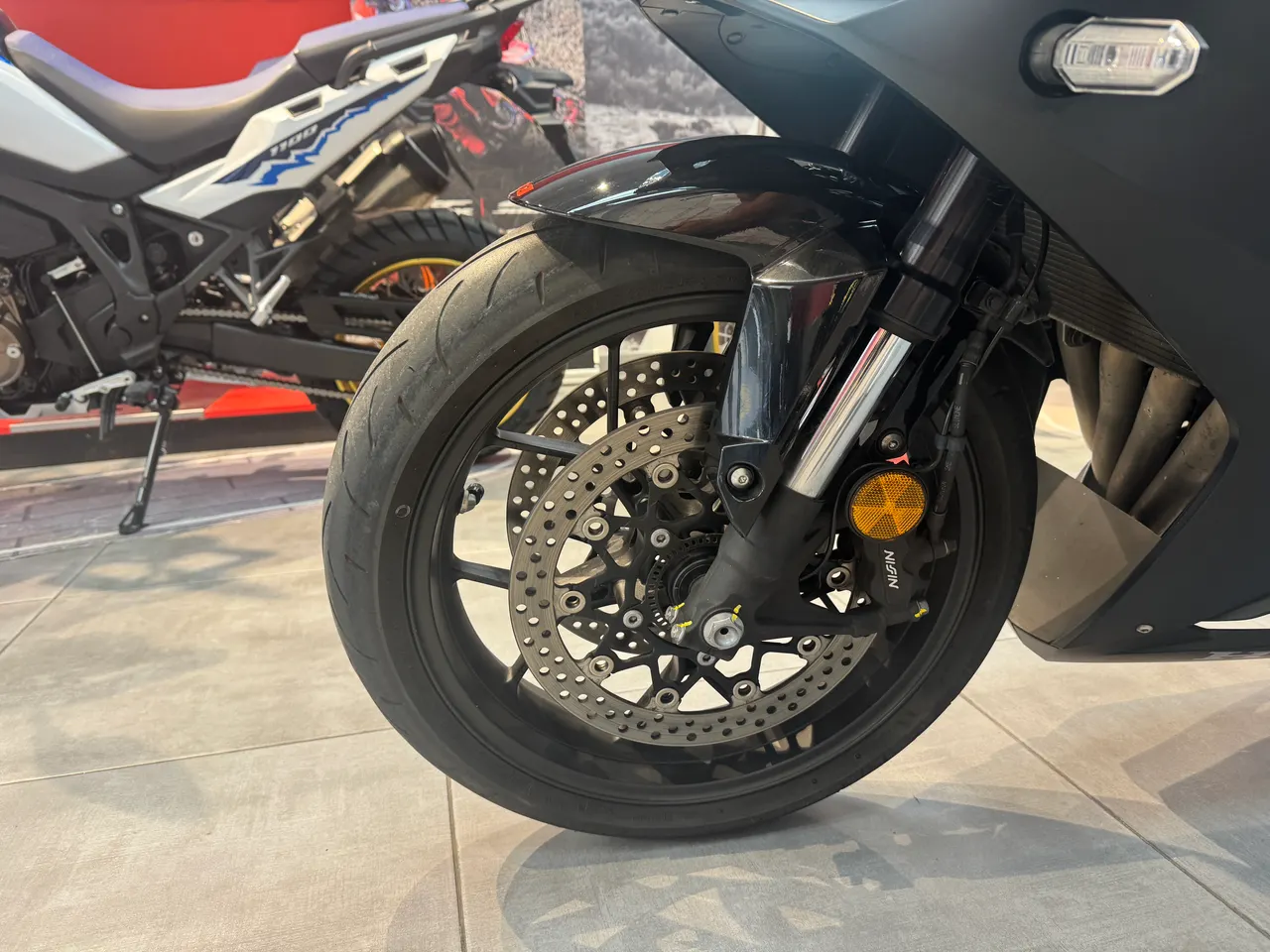 Primer plano de la rueda delantera de una moto Honda negra.