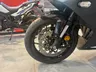 Primer plano de la rueda delantera de una moto Honda negra.