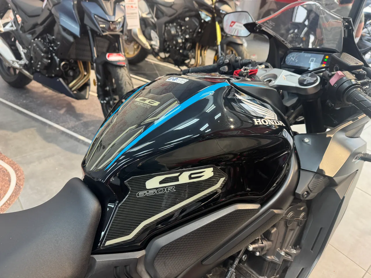 Vista lateral de una moto Honda CB650R negra con detalles azules
