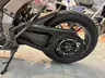 Detalle de la rueda trasera y basculante de una moto Honda WN7 negra graphite.